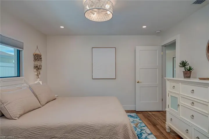 Bedroom featuring dark wood-style floors, recessed lighting, and a chandelier