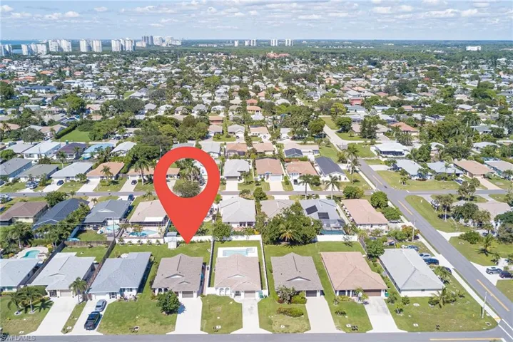 Aerial view of property and surrounding area featuring nearby suburban area