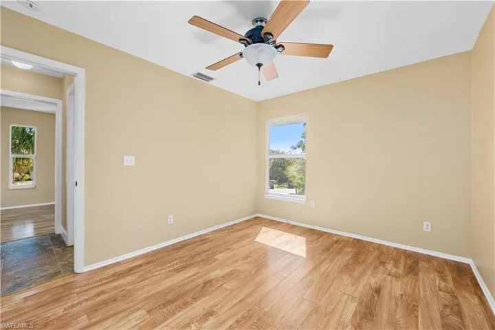Spare room with light wood finished floors and a ceiling fan