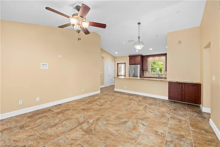Unfurnished living room with a ceiling fan, lofted ceiling, and recessed lighting