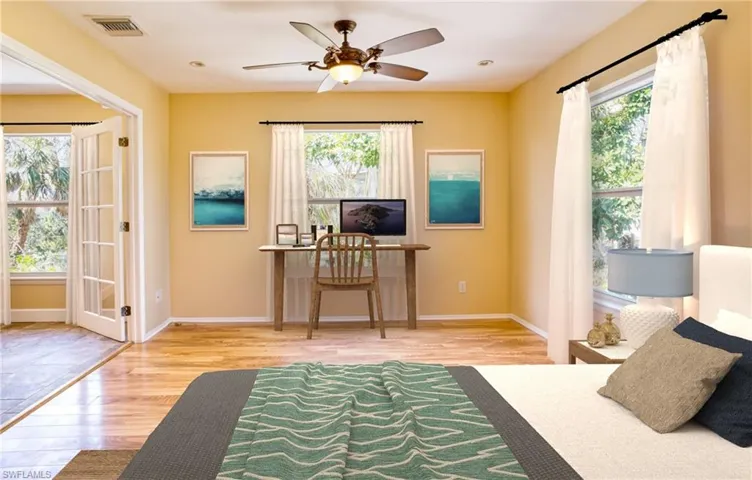 Bedroom with light wood-style flooring, multiple windows, and ceiling fan