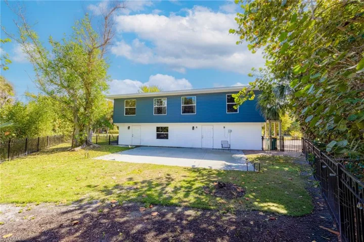 Rear view of house with a fenced backyard and stucco siding