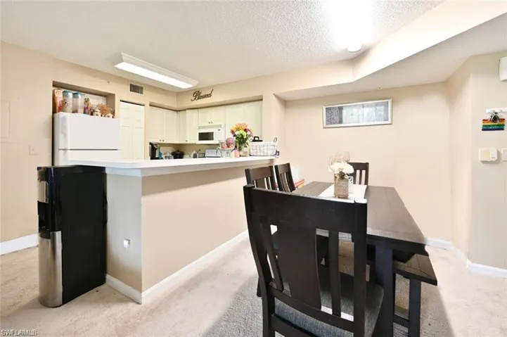 Carpeted dining space featuring a textured ceiling