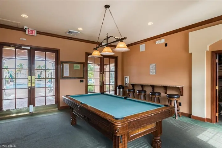 Game room with dark carpet, pool table, french doors, and ornamental molding