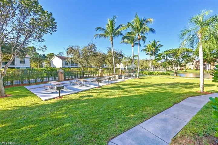 View of property's community with a water view and a lawn