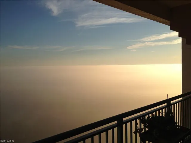 Balcony at dusk featuring a water view