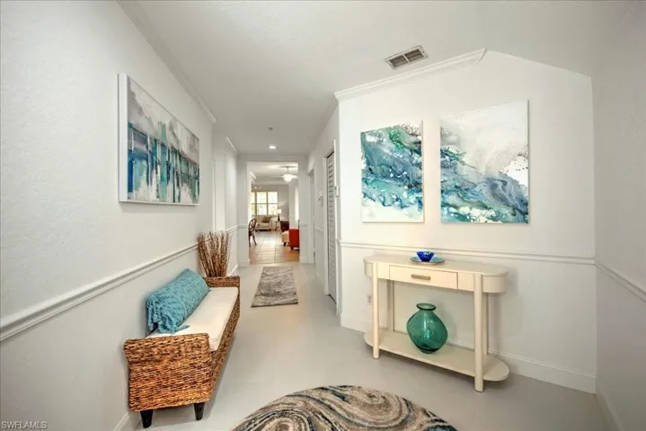 Hallway with ornamental molding and baseboards