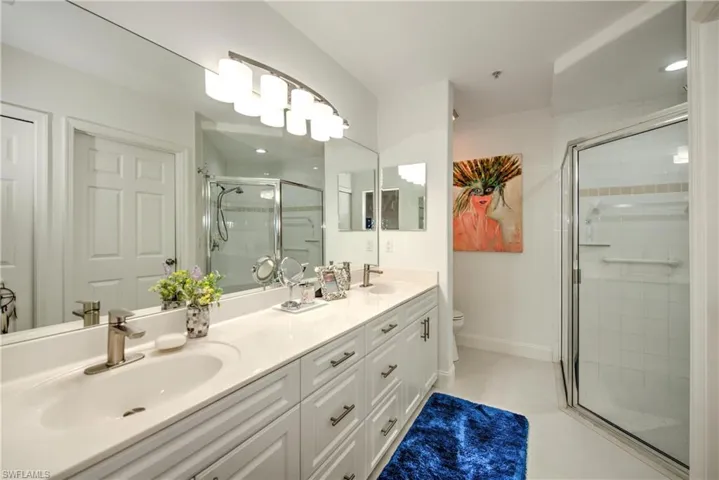 Bathroom featuring double vanity and a stall shower