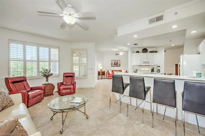 Living area featuring a ceiling fan, ornamental molding, recessed lighting, and light tile patterned floors