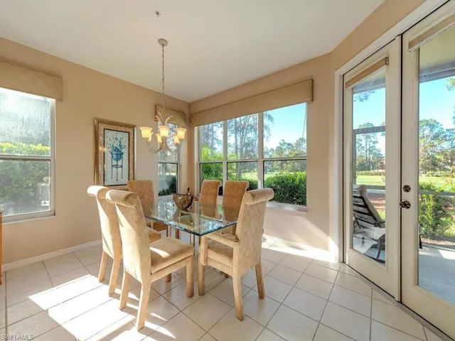 Tiled dining area with french doors, a notable chandelier, and plenty of natural light