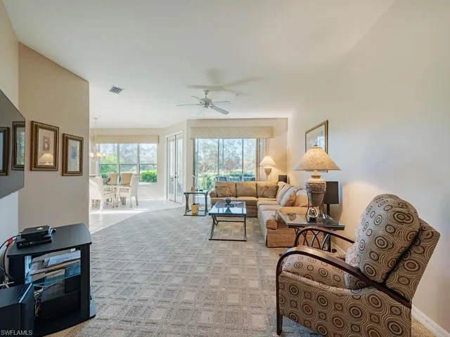 Living room with ceiling fan and light carpet