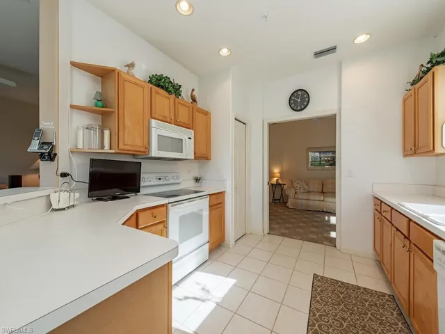 Kitchen with white appliances and light tile patterned floors