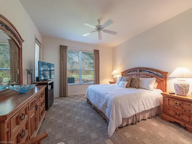Carpeted bedroom featuring ceiling fan