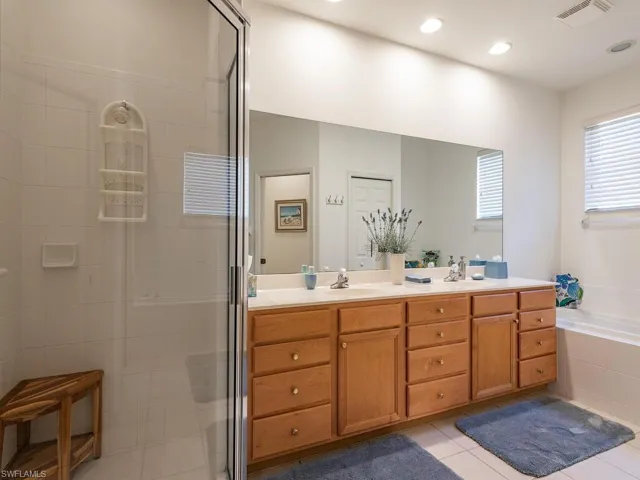 Bathroom with vanity, plus walk in shower, and tile patterned flooring