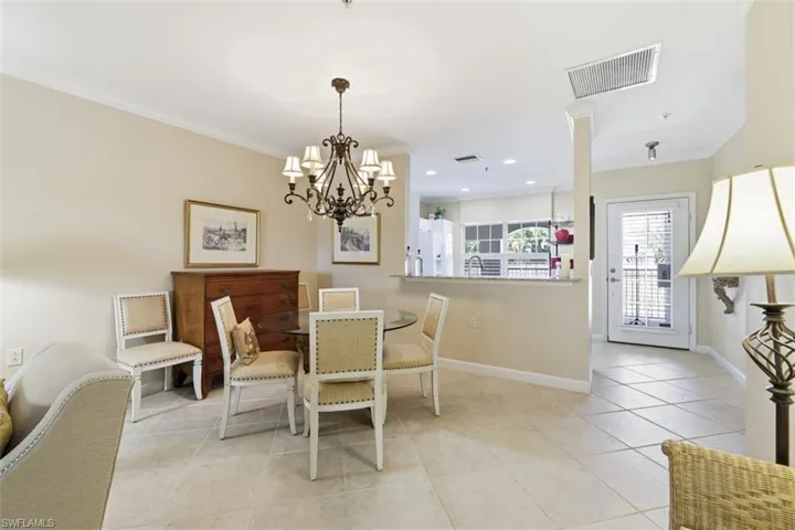 Dining area with crown molding, light tile patterned floors, and a chandelier