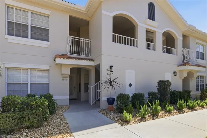 View of front of home featuring a balcony and stucco siding