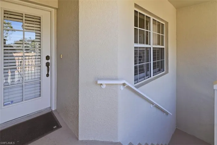 Doorway to property featuring stucco siding