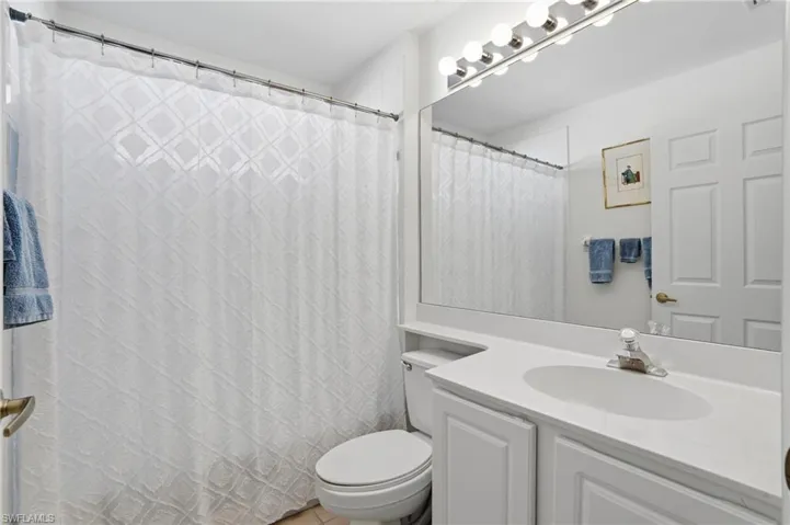 Bathroom with a shower with curtain and vanity