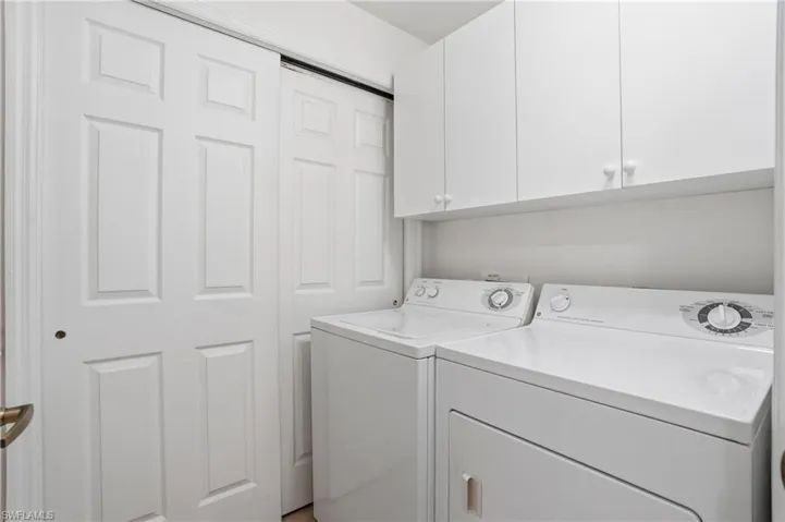 Laundry room featuring washer and clothes dryer and cabinet space