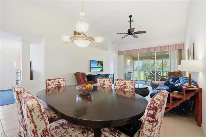 Dining space featuring light tile patterned floors, lofted ceiling, and ceiling fan