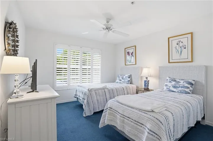 Bedroom with dark carpet and a ceiling fan