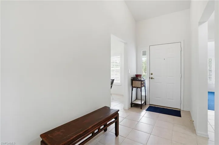 Foyer entrance with lofted ceiling and light tile patterned flooring