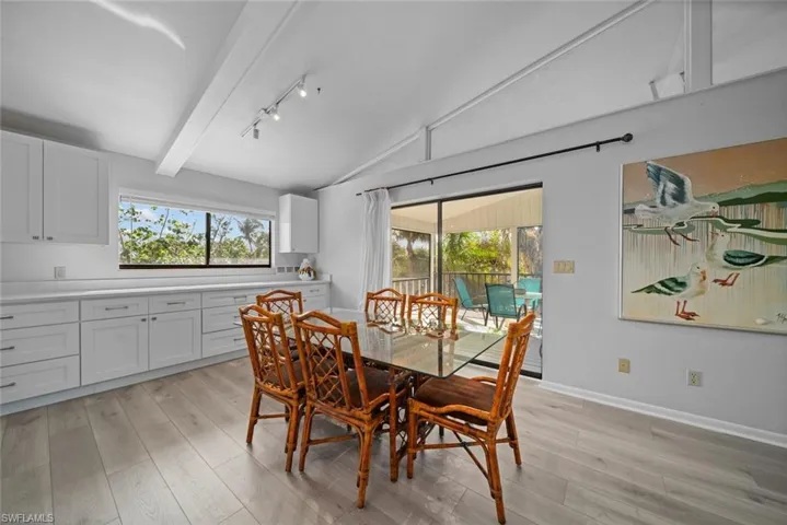 Dining room featuring light wood-style floors, healthy amount of natural light, and rail lighting