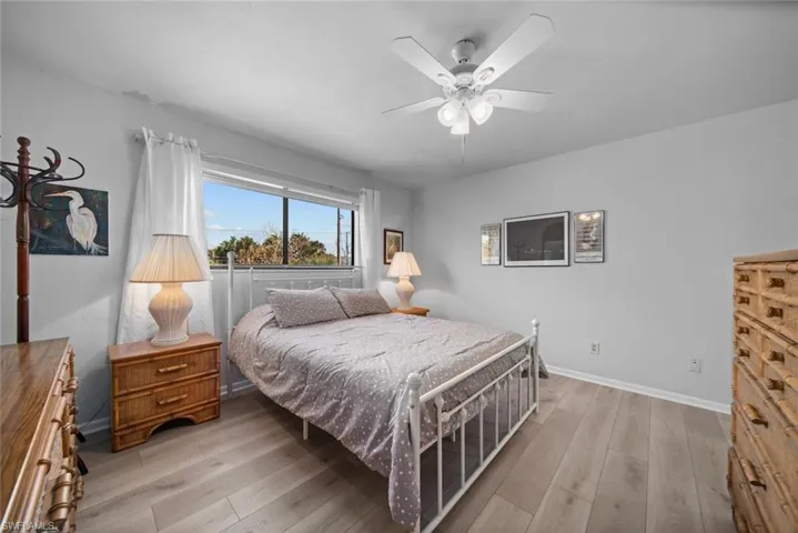 Bedroom with light wood finished floors, baseboards, and ceiling fan