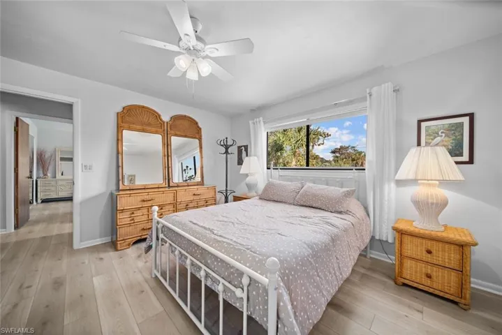 Bedroom featuring light wood-type flooring, baseboards, and a ceiling fan