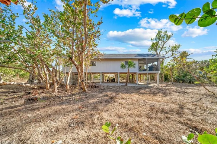 Rear view of property with a sunroom and roof with shingles