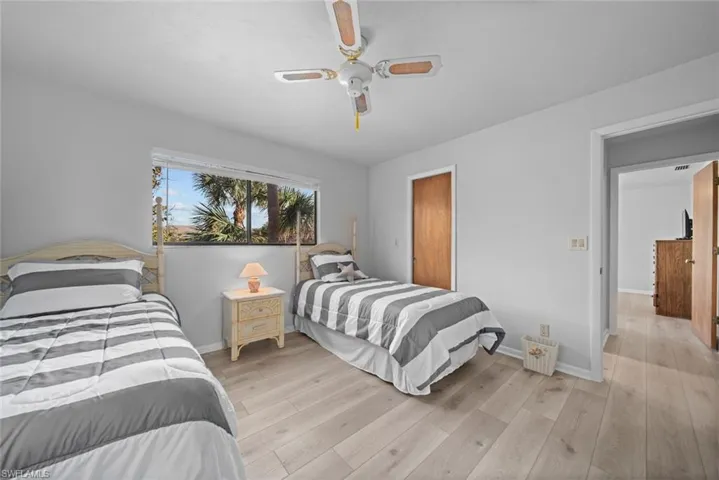 Bedroom with light wood-style floors, baseboards, and a ceiling fan