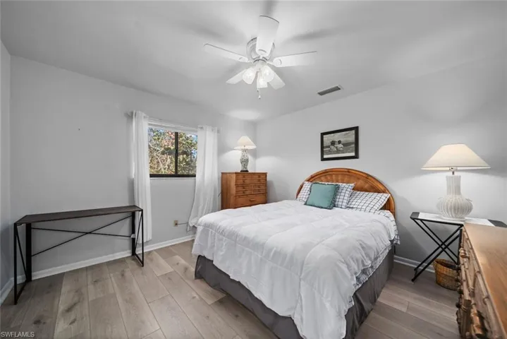 Bedroom with wood finished floors, baseboards, and ceiling fan