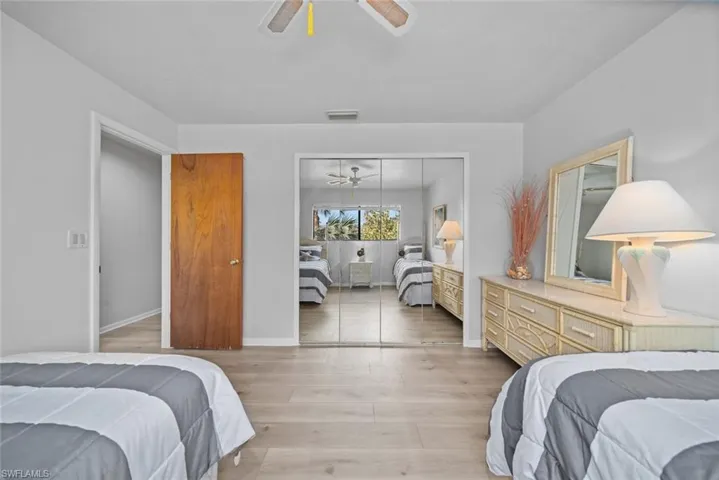 Bedroom with a closet, light wood finished floors, ceiling fan, and baseboards