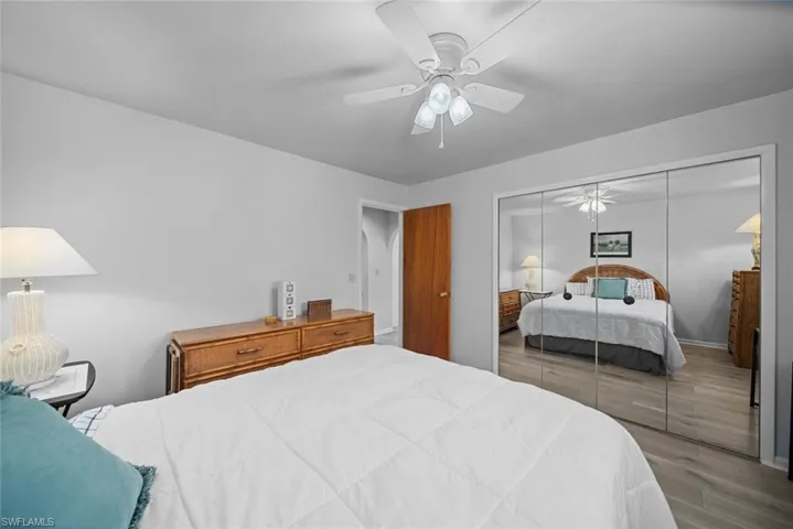 Bedroom with wood finished floors, a closet, and a ceiling fan
