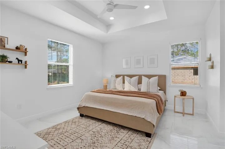 Bedroom with recessed lighting, a tray ceiling, and a ceiling fan