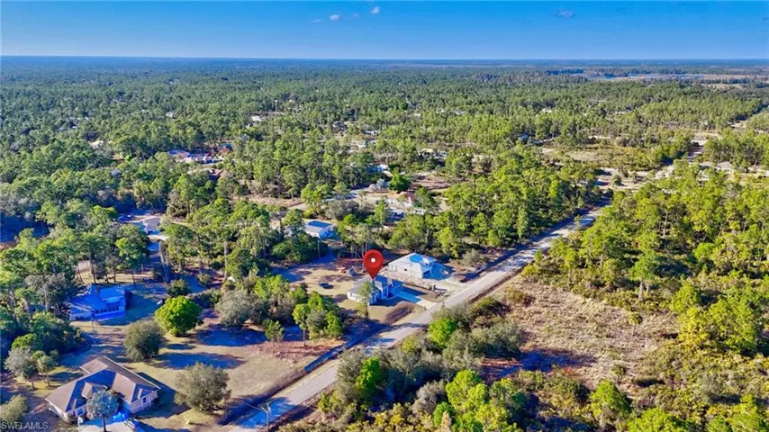 View of property location with a heavily wooded area