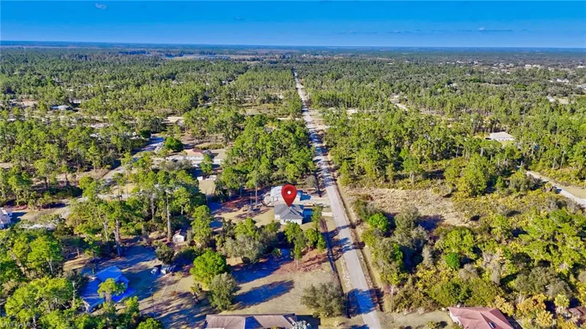 Aerial view of property and surrounding area featuring a heavily wooded area