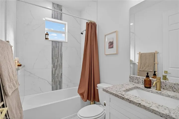 Full bath featuring shower / tub combo with curtain and vanity
