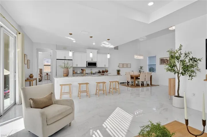 Living area with light marble finish flooring and recessed lighting