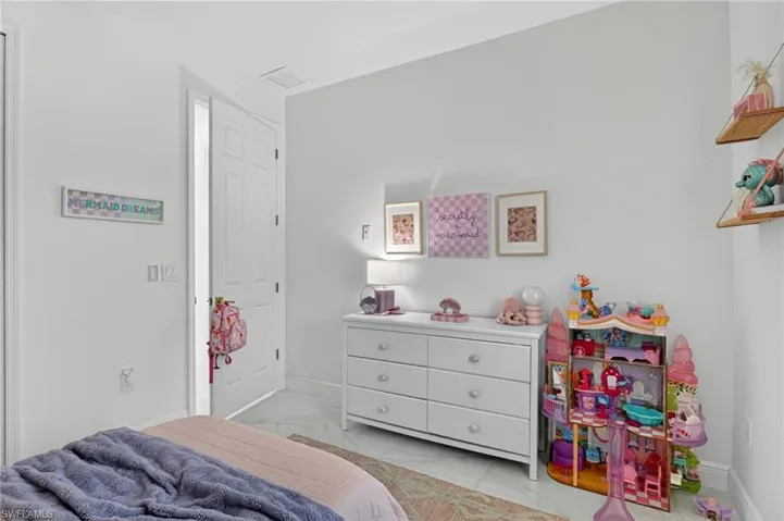 Bedroom with baseboards and light marble finish floors