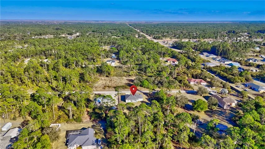 Aerial overview of property's location featuring a forest and nearby suburban area