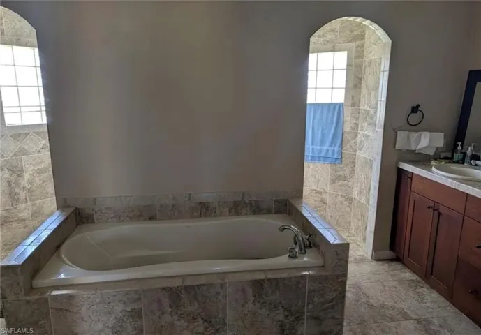 Full bathroom with vanity and a bath