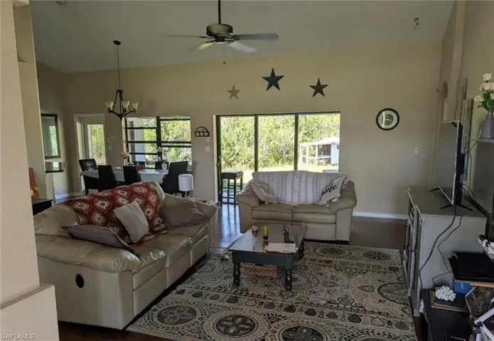 Living room featuring a chandelier, wood finished floors, and a ceiling fan