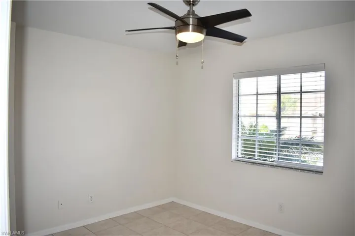 Guest Bedroom with Light Tile and Ceiling Fan with Partial Lake View