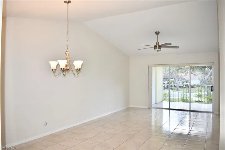 Living/Dining Room with Light Tile, Vaulted Ceiling, Chandelier