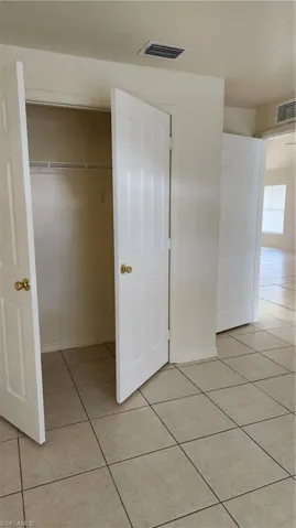 Unfurnished bedroom with light tile patterned floors and a closet