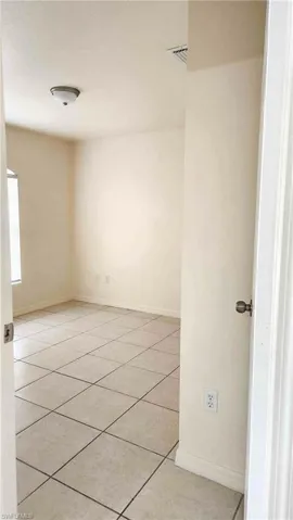 Empty room featuring baseboards and light tile patterned floors