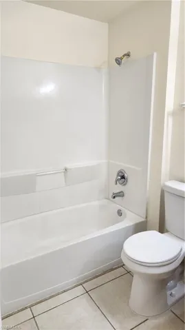 Full bath featuring light tile patterned floors and  shower combination