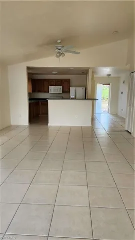 Unfurnished living room featuring light tile patterned floors and ceiling fan