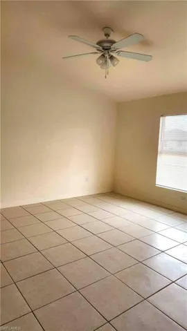Unfurnished room featuring a ceiling fan and light tile patterned flooring